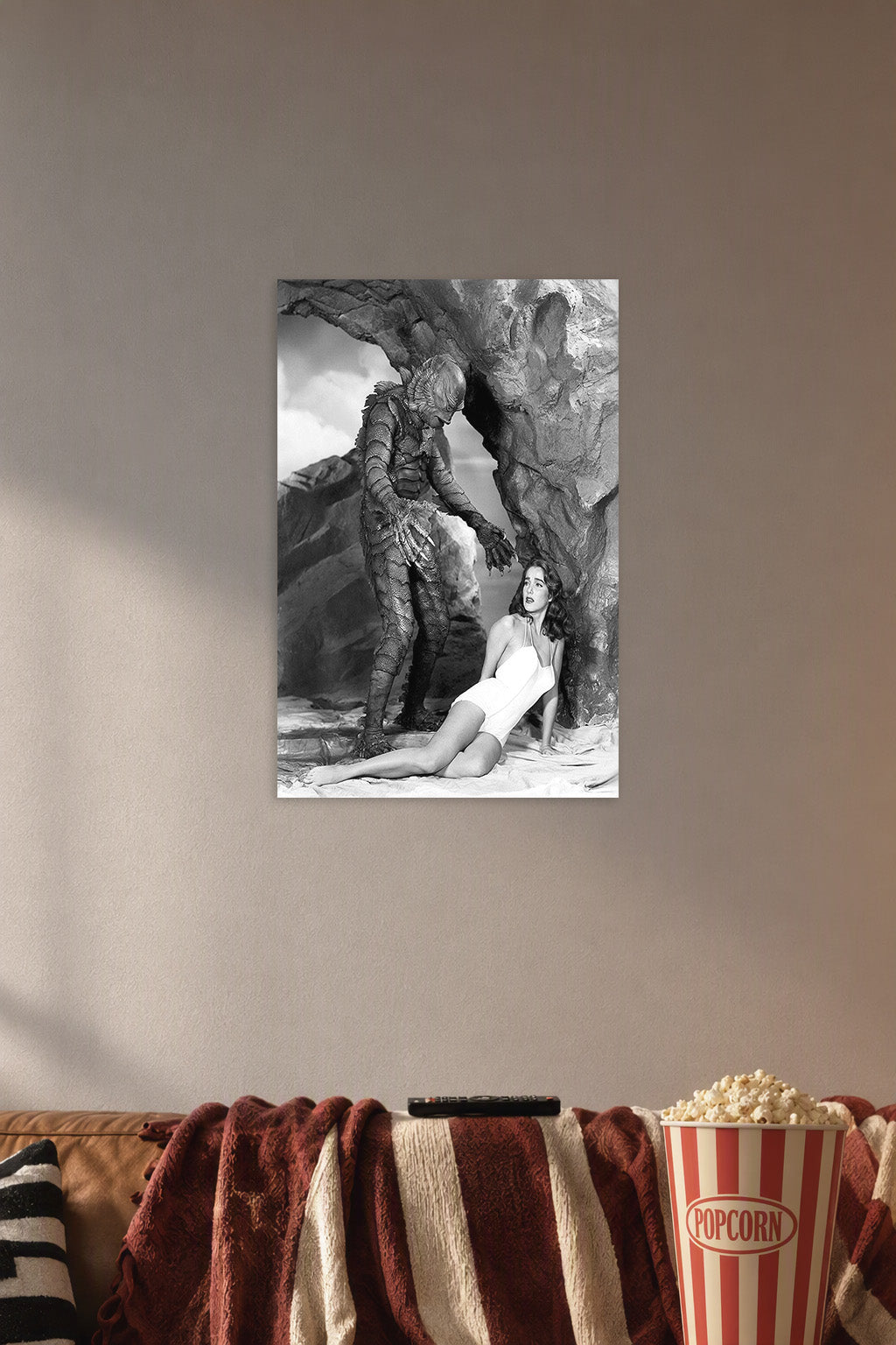 Creature From The Black Lagoon in a cozy movie room above a brown sofa with popcorn.