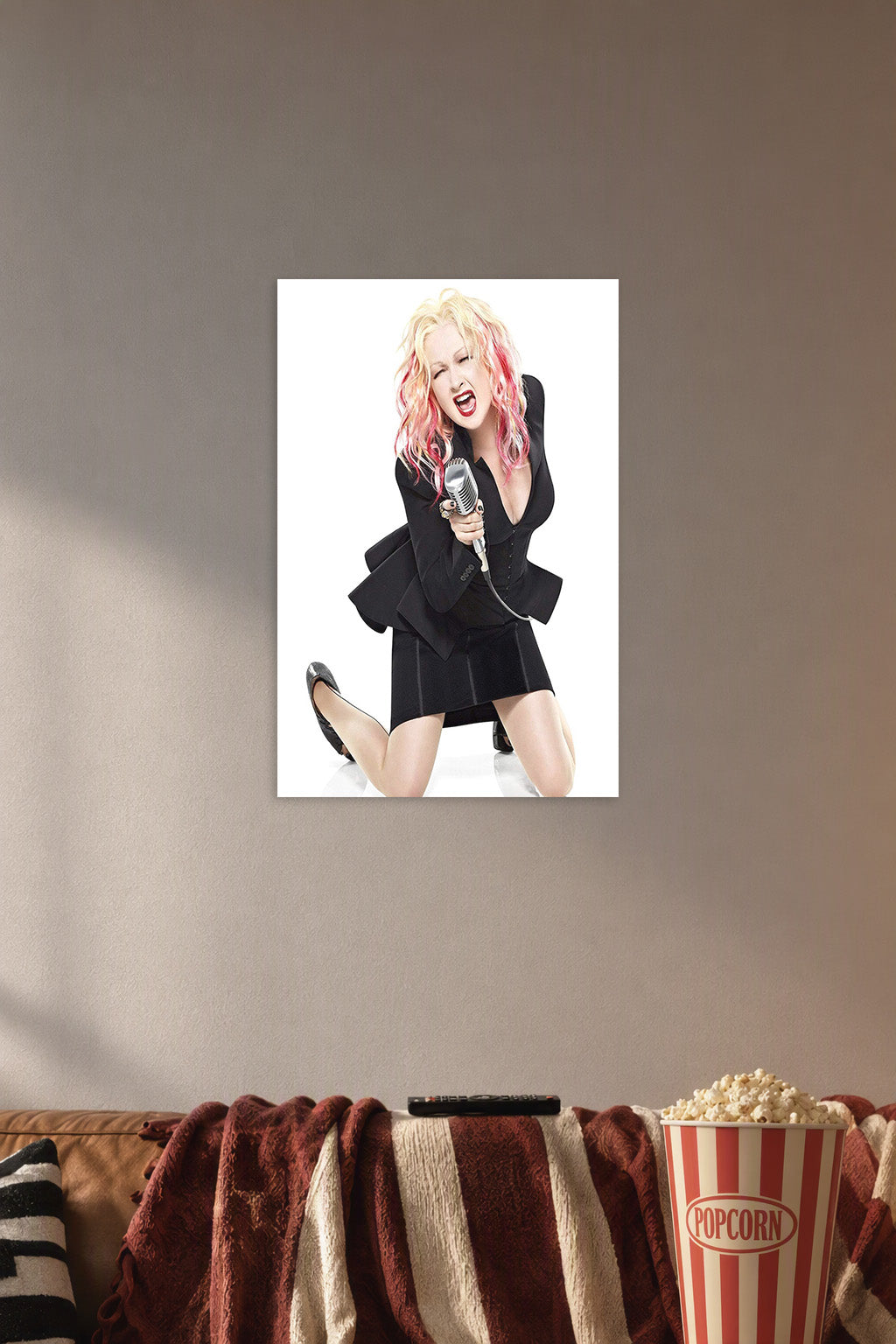 Cyndi Lauper in a cozy movie room above a brown sofa with popcorn.