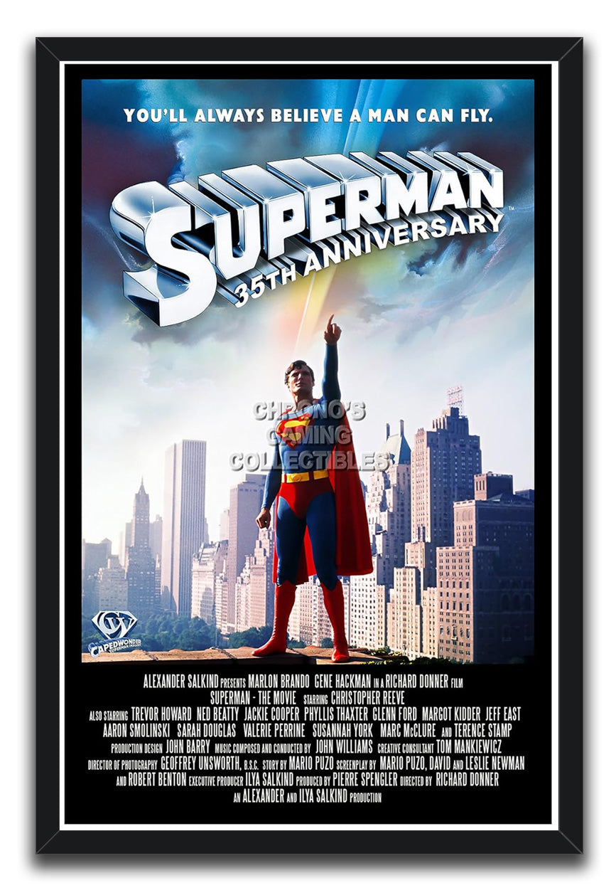 Superman 35th Anniversary framed wall art print featuring the caped hero pointing skyward before city buildings and blue clouds.