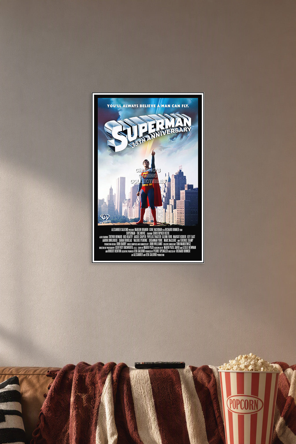 DC Superman 35th Anniversary Movie in a cozy movie room above a brown sofa with popcorn.