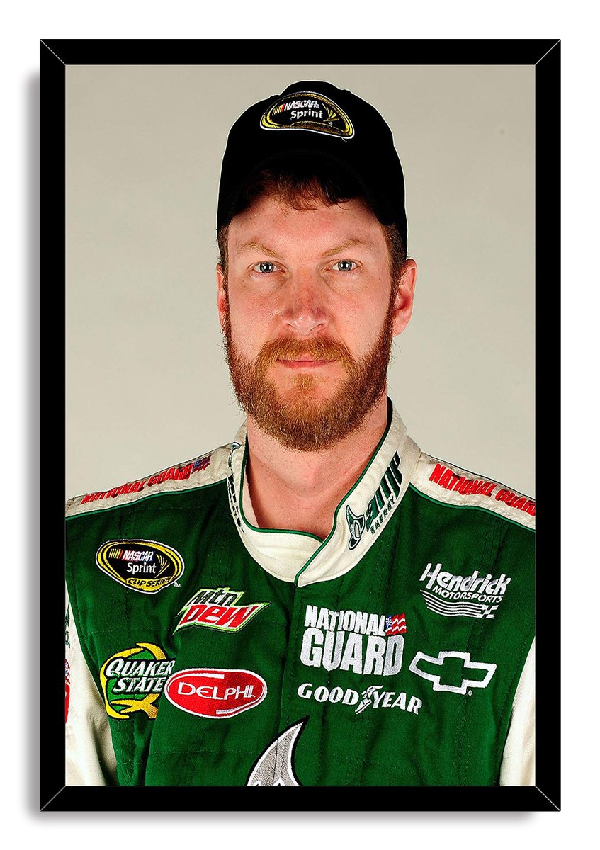 Dale Earnhardt Jr. framed wall art print with a black border, green racing uniform, NASCAR cap, and plain beige backdrop.
