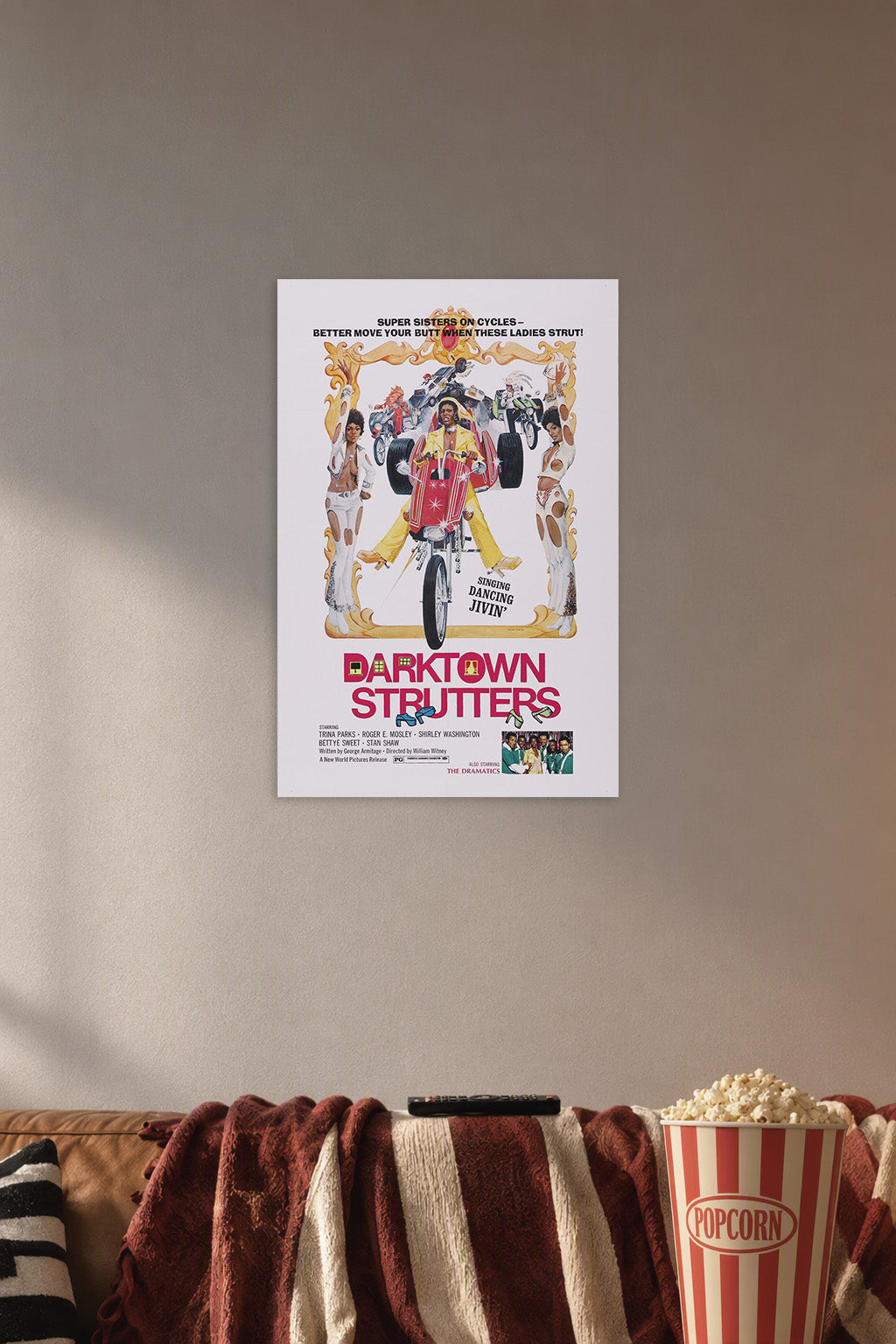 Darktown Strutters Blaxploitation Movie Poster in a cozy movie room above a brown sofa with popcorn.