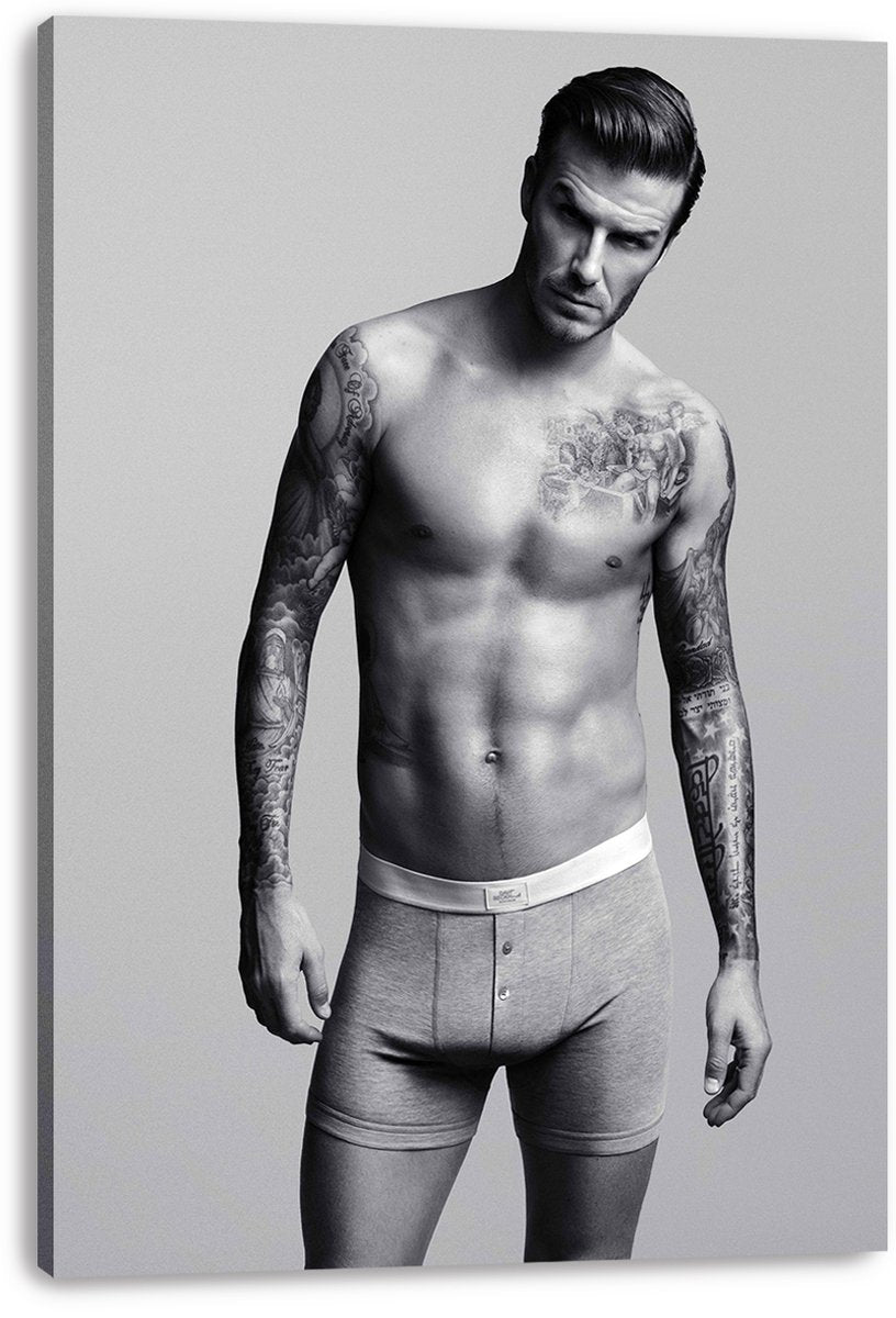 David Beckham canvas wall art print presents a monochrome portrait of the tattooed man standing in gray boxer briefs.