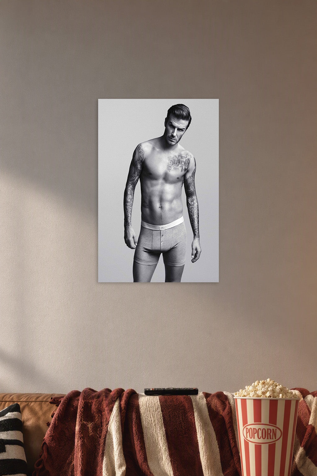 David Beckham in a cozy movie room above a brown sofa with popcorn.