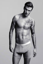 David Beckham poster features a black-and-white full-length portrait of the shirtless, tattooed man in gray boxer briefs.