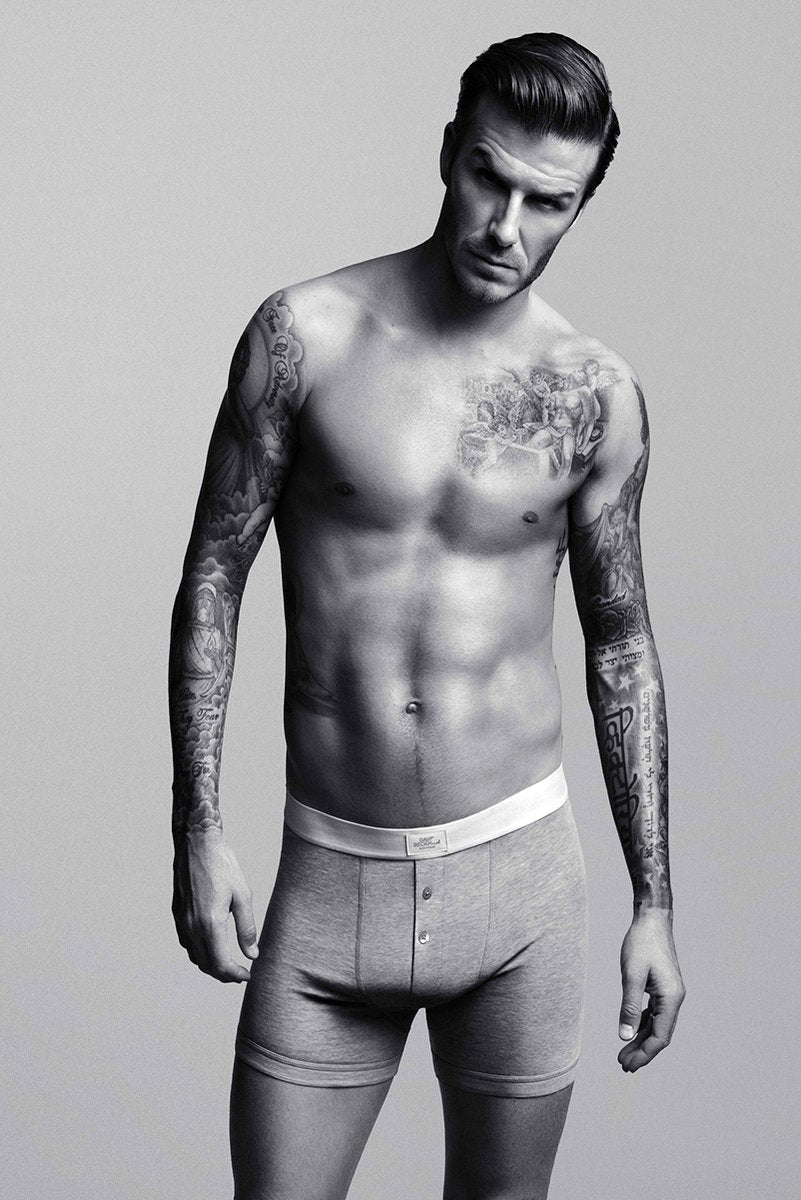 David Beckham poster features a black-and-white full-length portrait of the shirtless, tattooed man in gray boxer briefs.