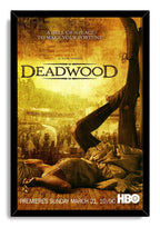 Deadwood framed wall art print in a black frame, featuring a sepia frontier street, fallen woman, raised boots, and HBO text.