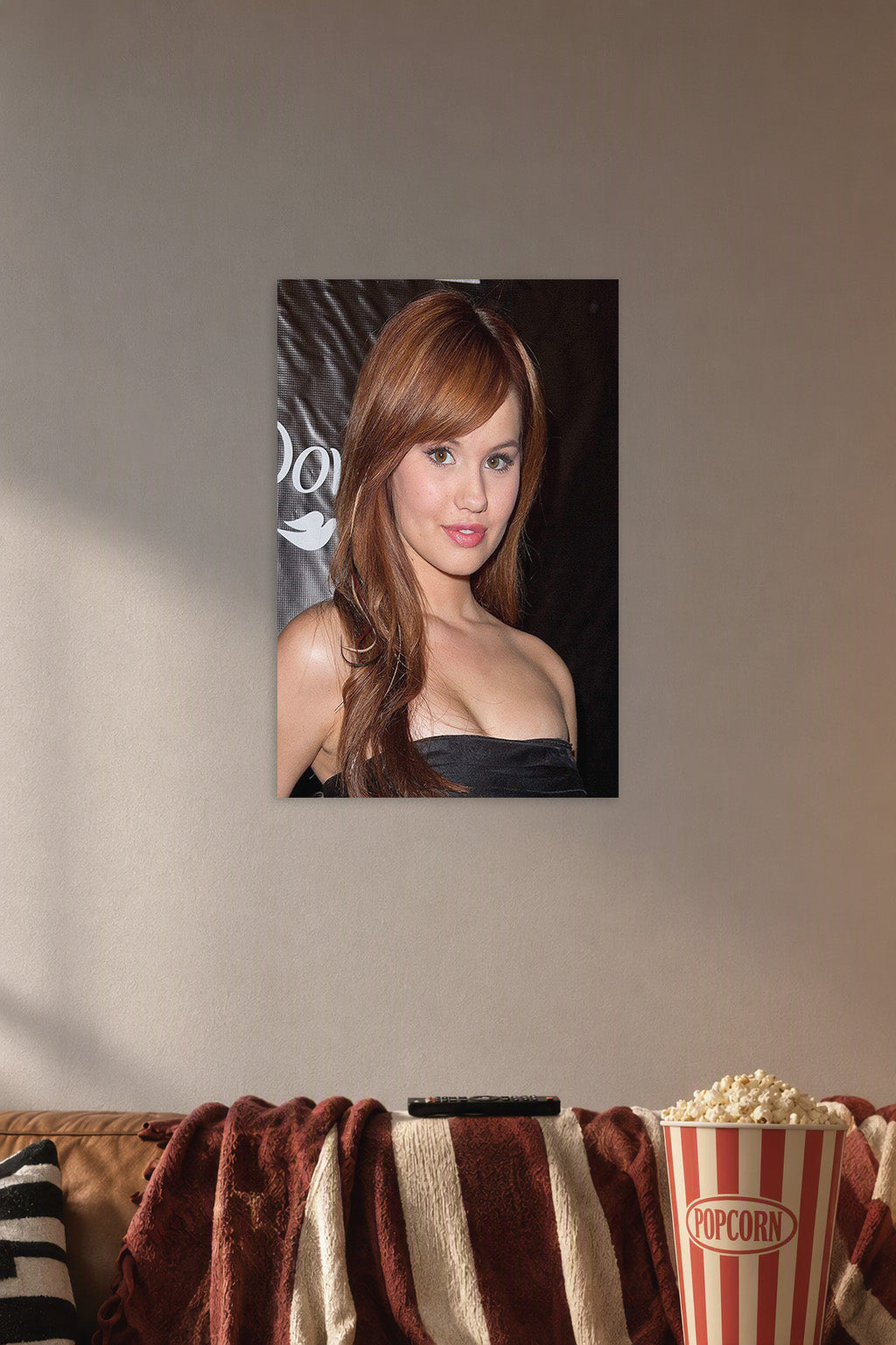 Debby Ryan in a cozy movie room above a brown sofa with popcorn.