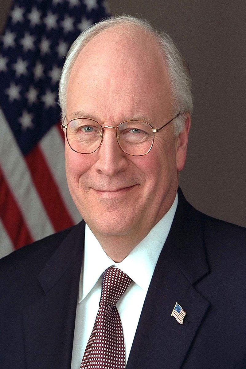 Dick Cheney poster portrait with him in glasses, a navy suit and patterned red tie before a softly blurred American flag.