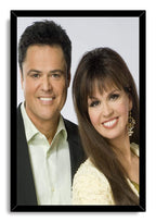Donny and Marie Osmond framed wall art print with a black border around their smiling formal portrait.