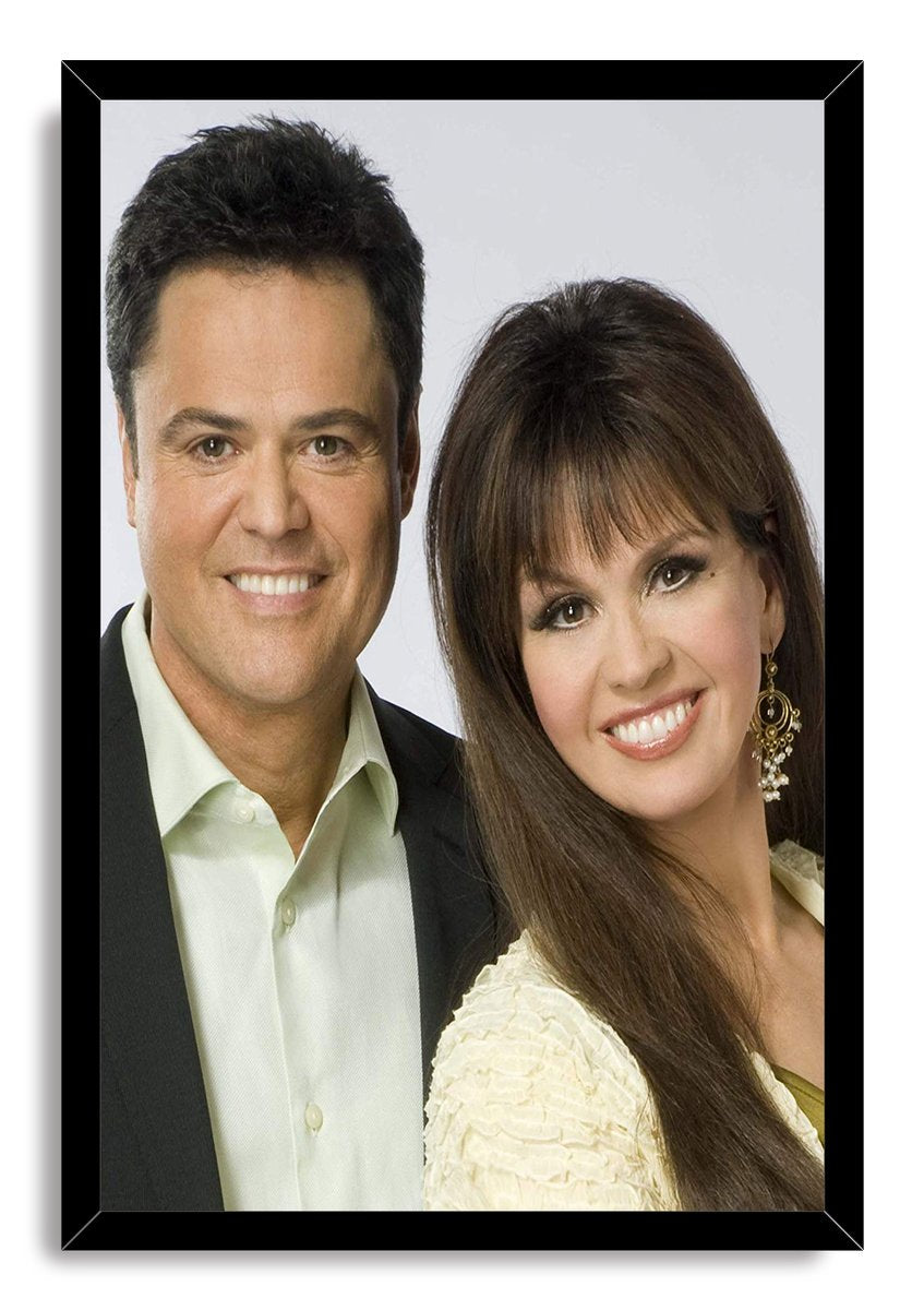 Donny and Marie Osmond framed wall art print with a black border around their smiling formal portrait.
