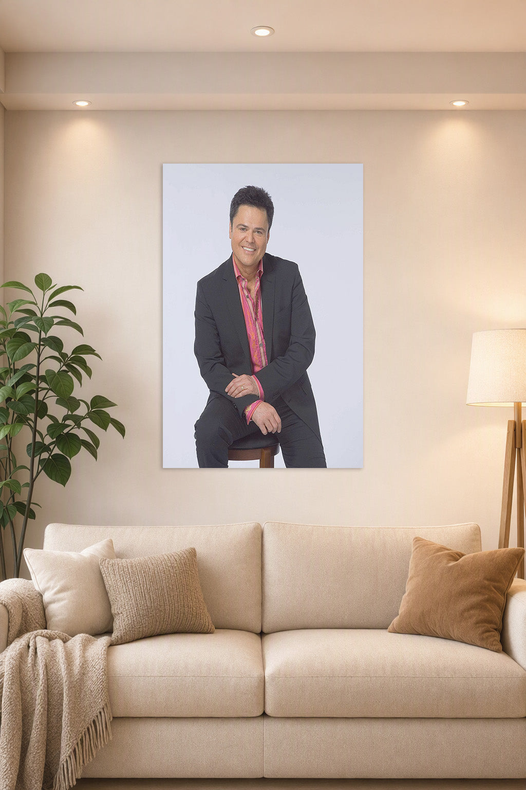 Donny Osmond in a bright living room above a beige sofa.