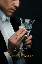Downton Abbey poster features a tuxedoed butler polishing a cut-crystal glass against a deep black background, with gold title text.