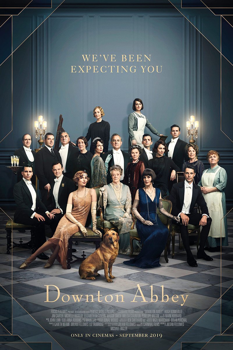 Downton Abbey poster features the ensemble in formal period attire around seated women and a golden dog in a blue paneled hall.