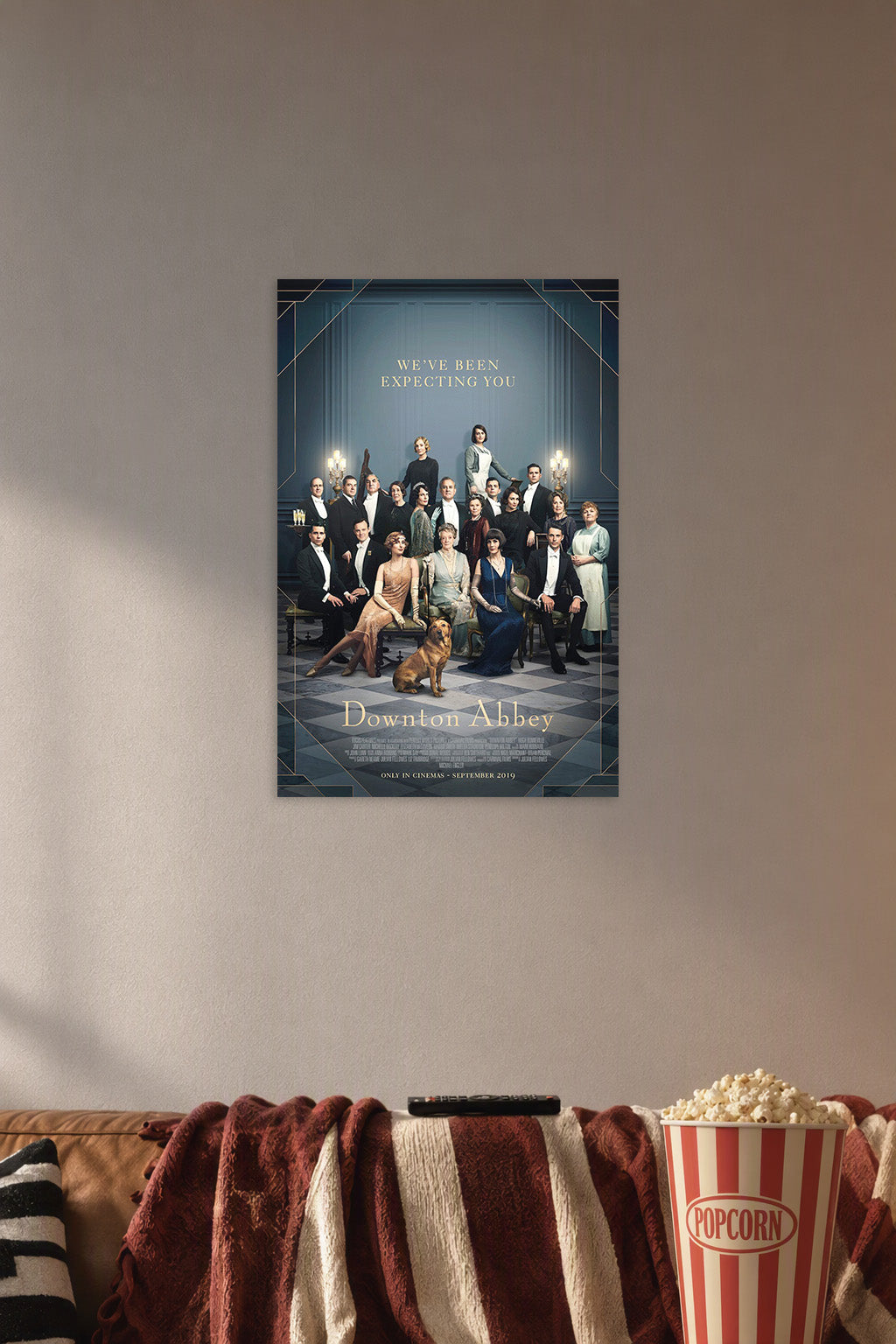 Downton Abbey Movie in a cozy movie room above a brown sofa with popcorn.