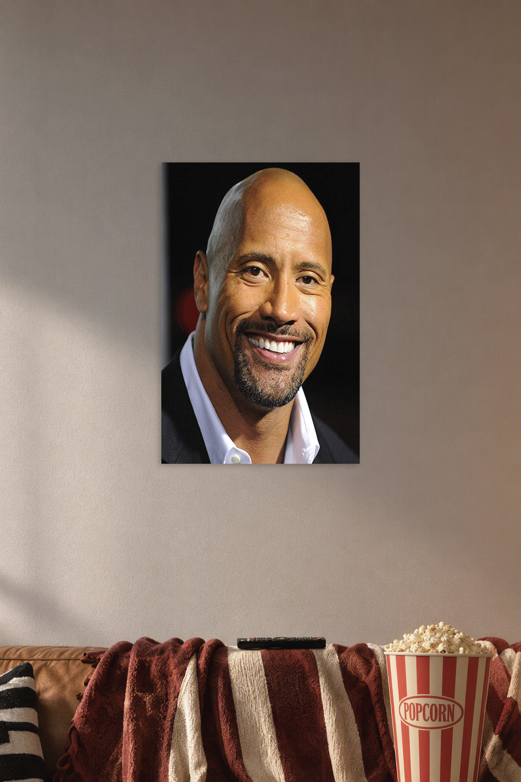 Dwayne 'The Rock' Johnson in a cozy movie room above a brown sofa with popcorn.