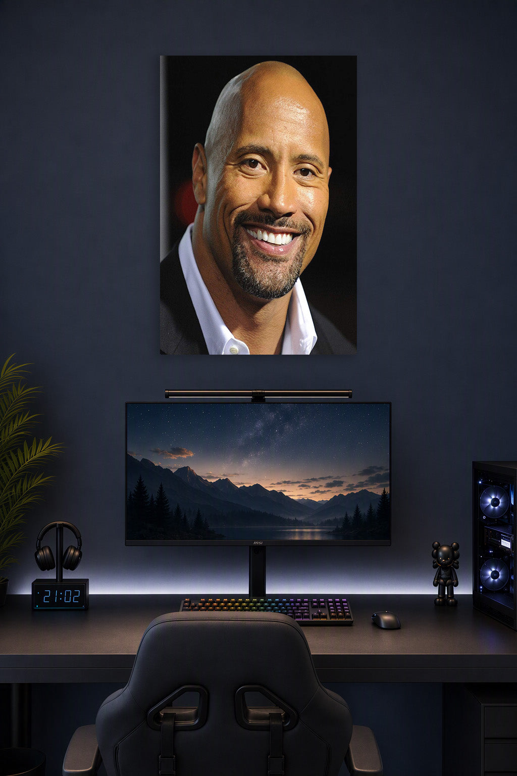 Dwayne 'The Rock' Johnson in a gaming desk setup above a monitor.