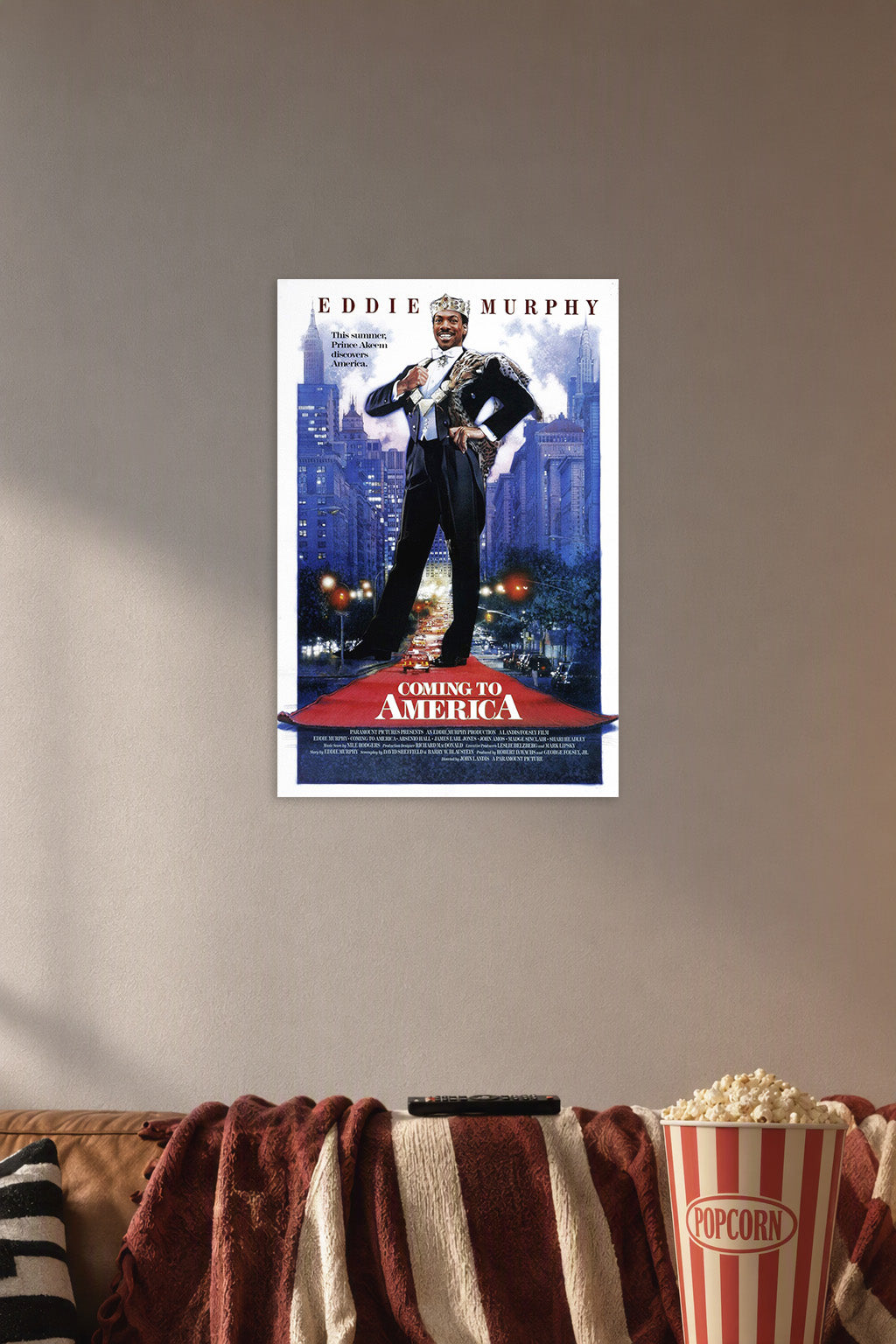 Eddie Murphy Prince Akeem Coming to America in a cozy movie room above a brown sofa with popcorn.