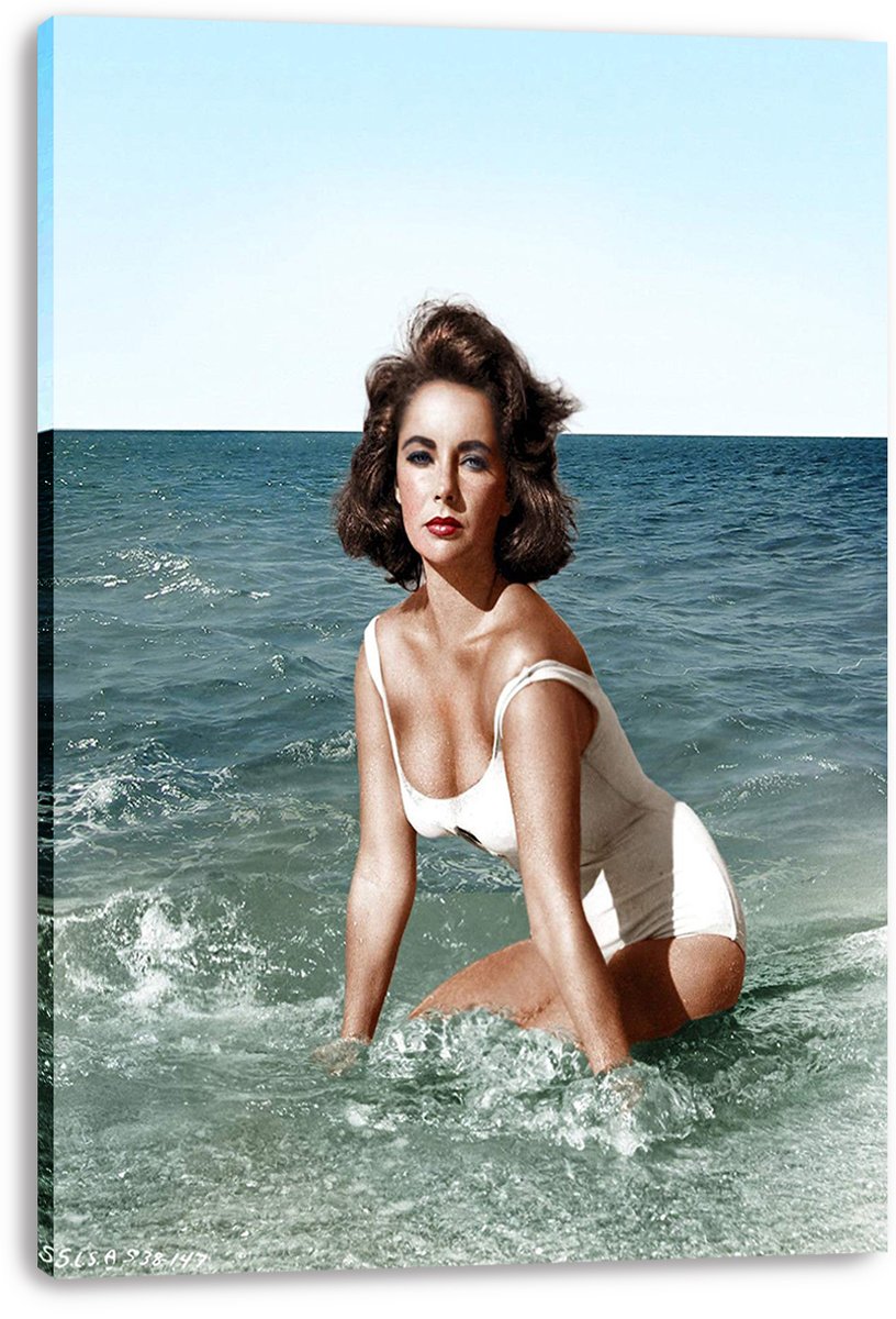Elizabeth Taylor canvas wall art print features the actress in a white swimsuit kneeling among ocean waves, with wrapped edges visible.