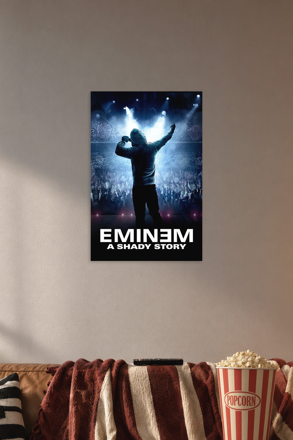 Eminem in a cozy movie room above a brown sofa with popcorn.