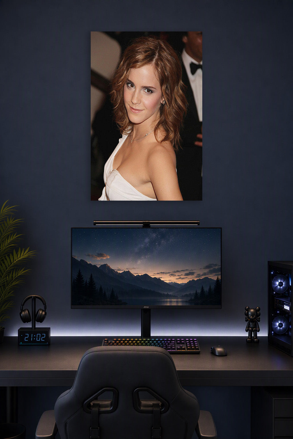 Emma Watson in a gaming desk setup above a monitor.