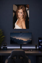 Emma Watson in a gaming desk setup above a monitor.