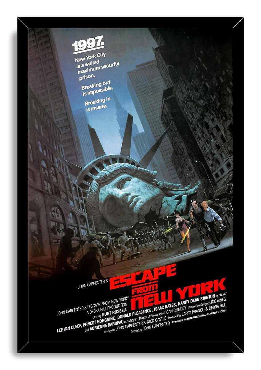Escape from New York wall art print in a black frame depicts a fallen Statue of Liberty head and figures running through Manhattan.