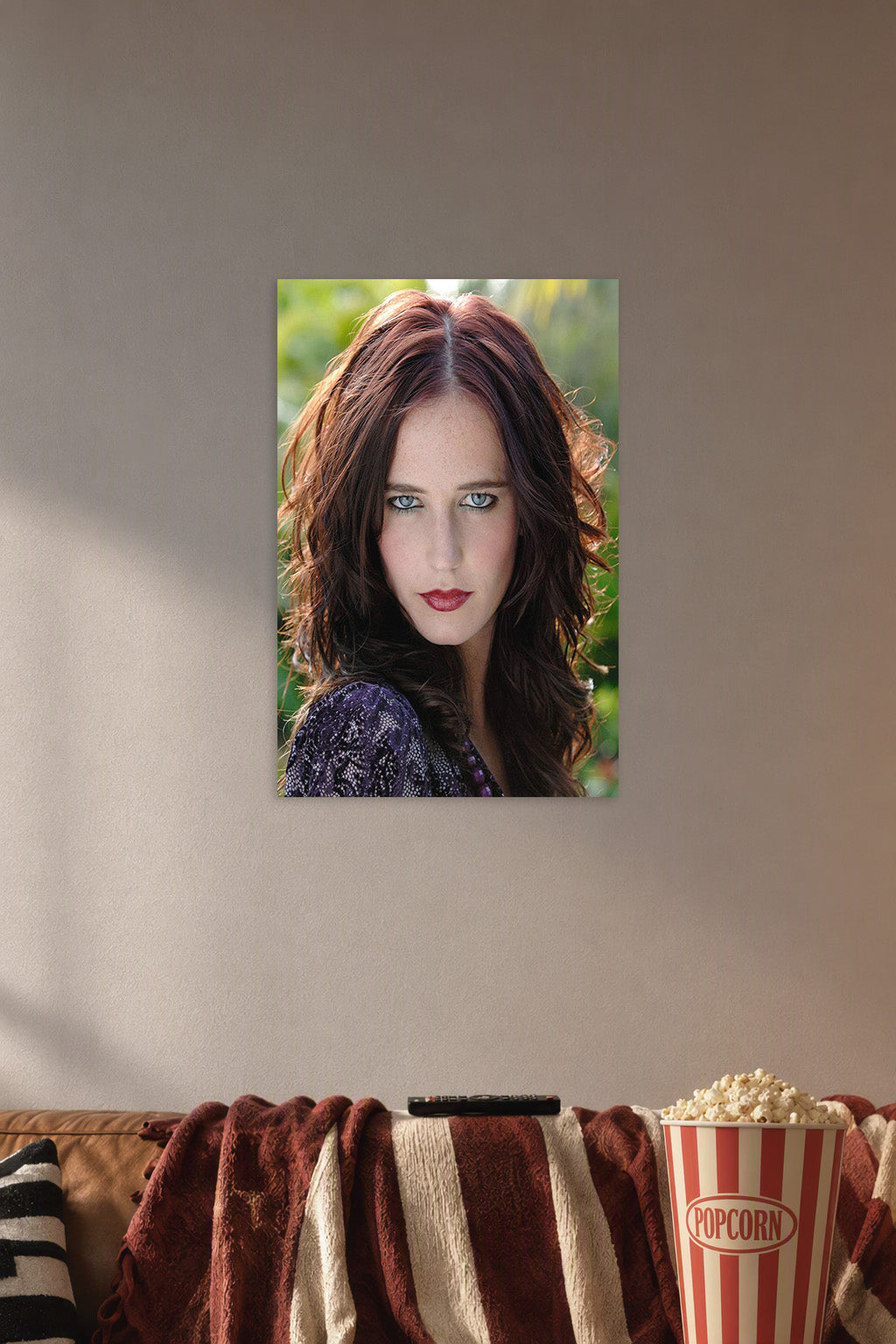 Eva Green in a cozy movie room above a brown sofa with popcorn.