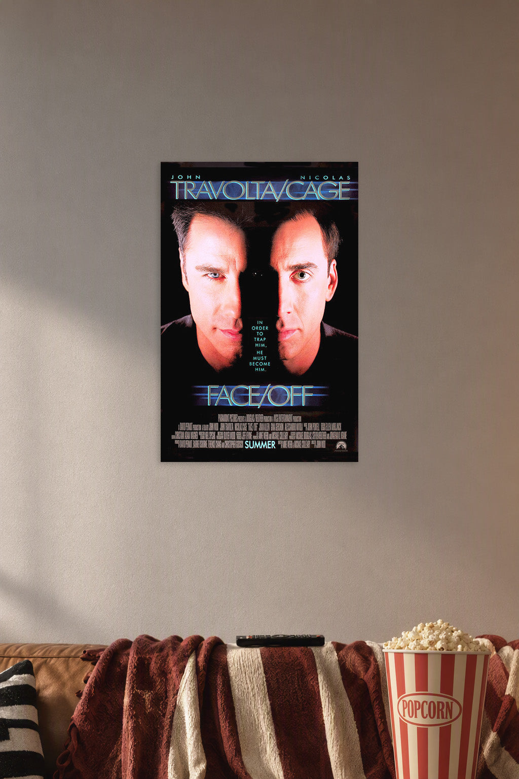 Face/Off John Travolta Nicolas Cage in a cozy movie room above a brown sofa with popcorn.