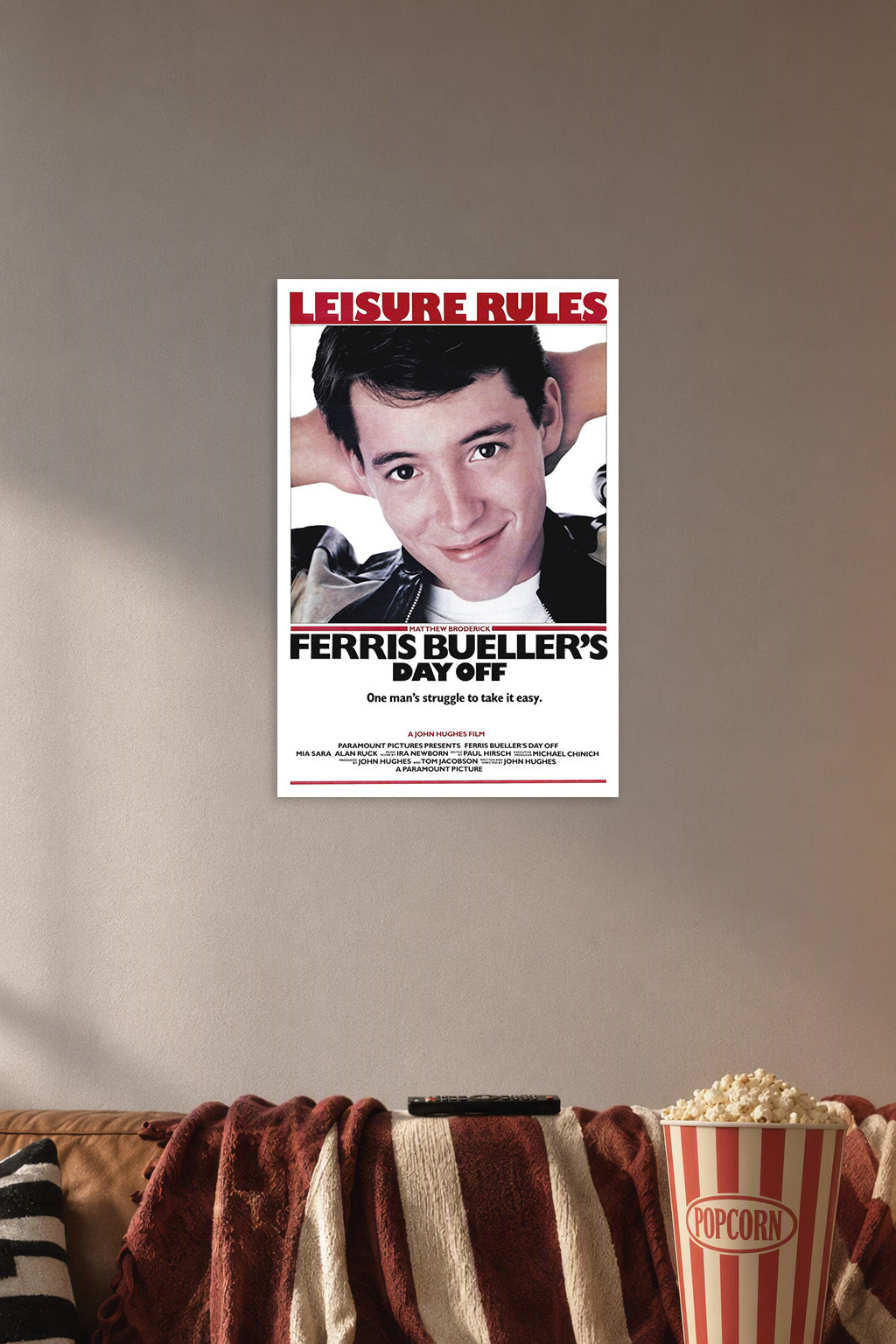Ferris Bueller's Day Off Movie Poster in a cozy movie room above a brown sofa with popcorn.