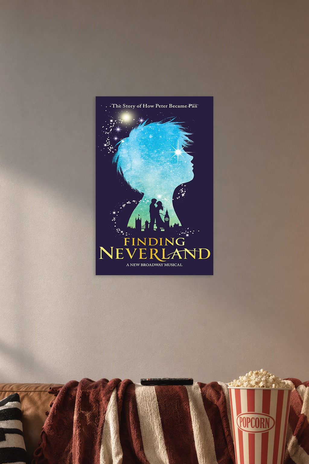 Finding Neverland Musical Poster in a cozy movie room above a brown sofa with popcorn.