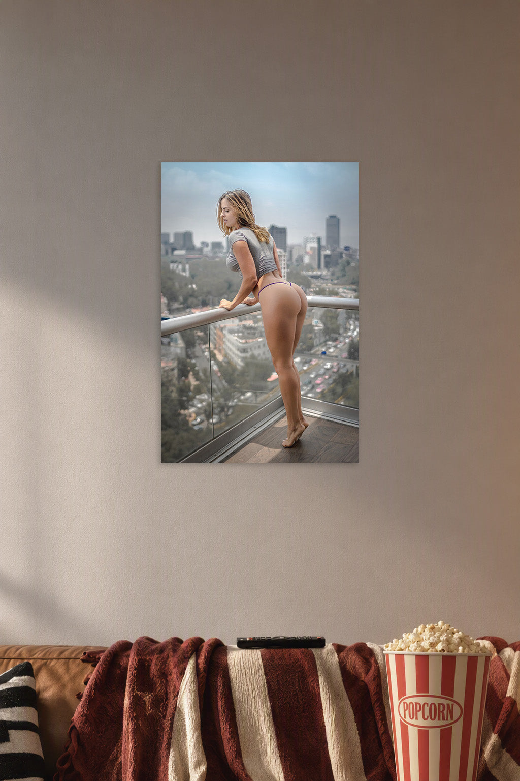 Fit Woman on Balcony in a cozy movie room above a brown sofa with popcorn.