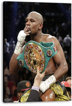 Floyd Mayweather canvas wall art print features the boxer with wrapped hands and a green gold championship belt against a dark arena crowd.