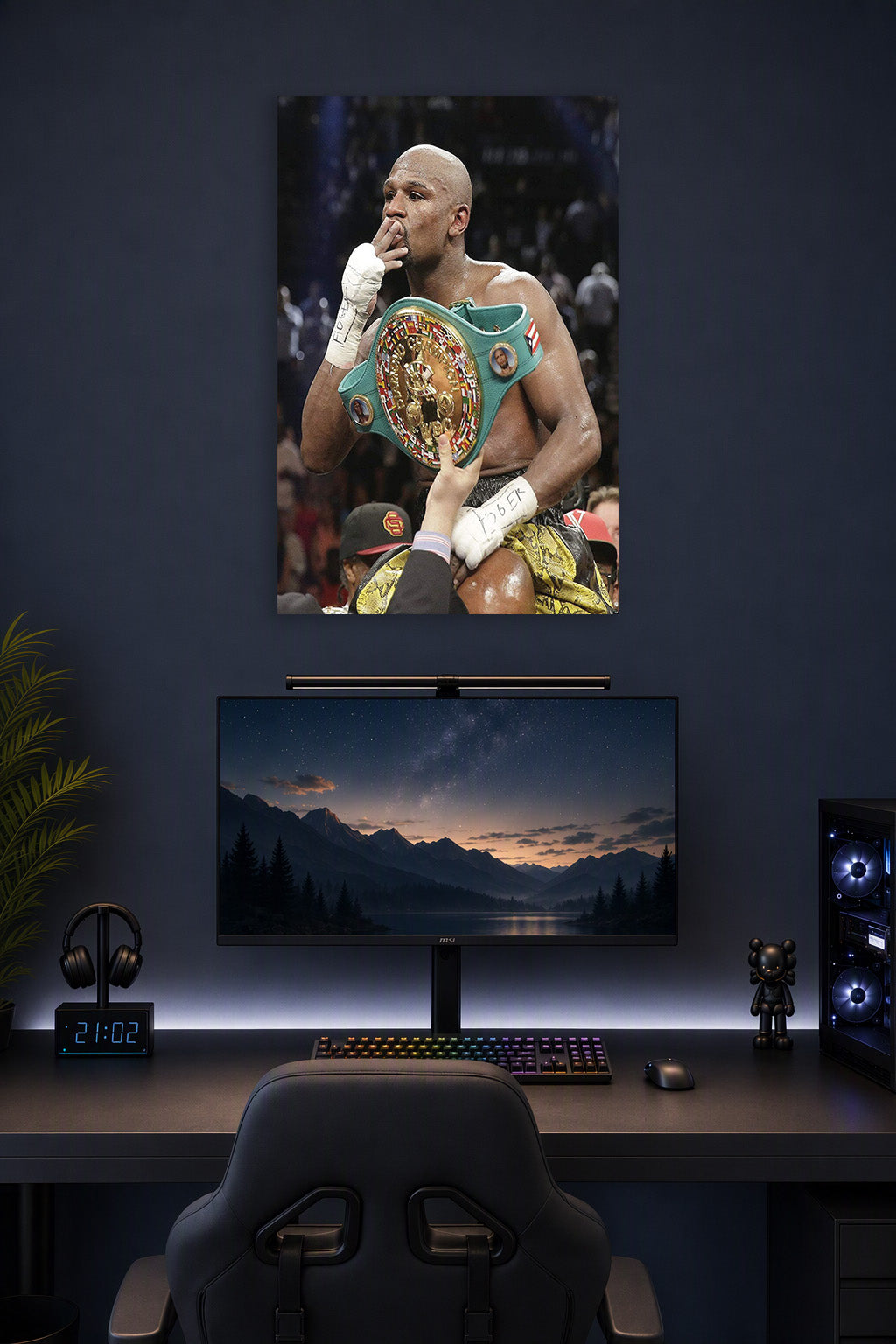 Floyd Mayweather in a gaming desk setup above a monitor.
