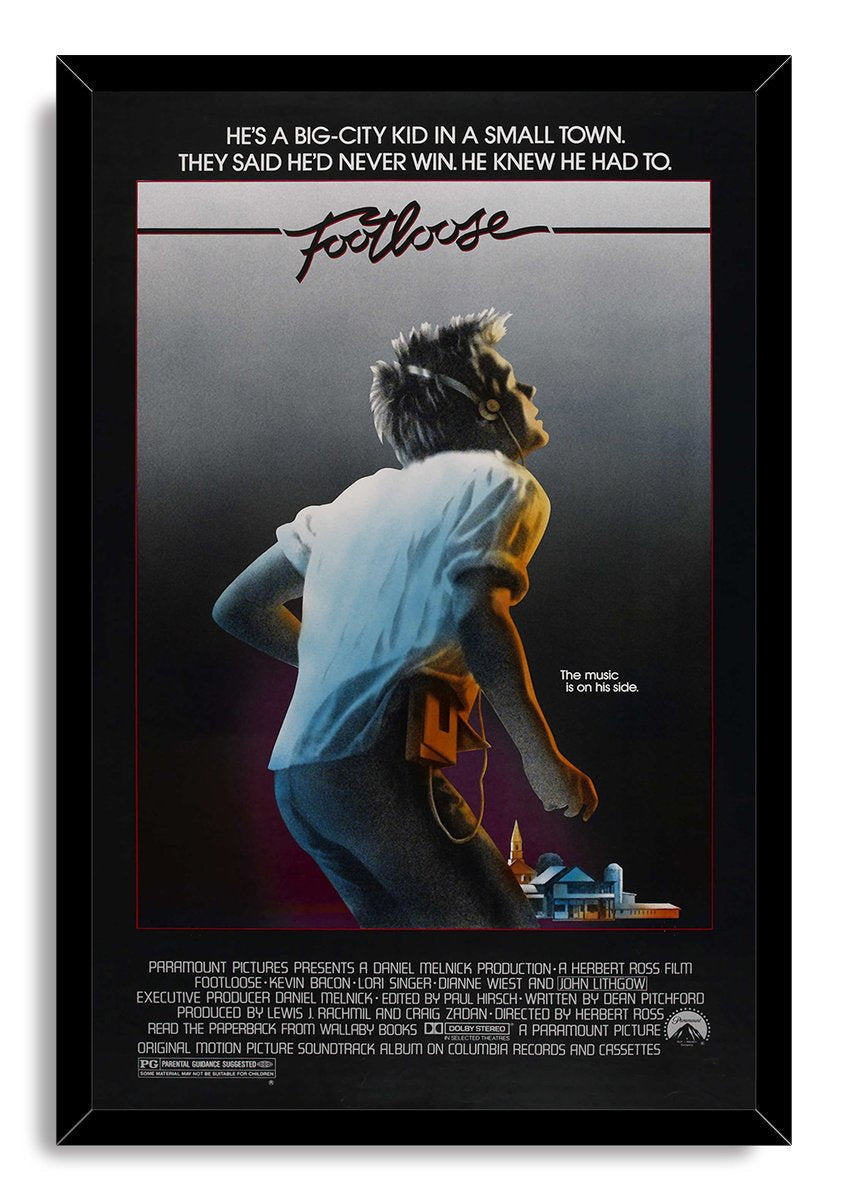 Footloose movie poster wall art print in a black frame, featuring a headphone-wearing young man and small town skyline.