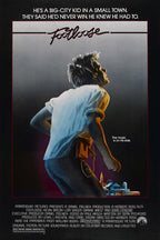 Footloose movie poster wall art print featuring a headphone-wearing young man in a white shirt above a small town at night.