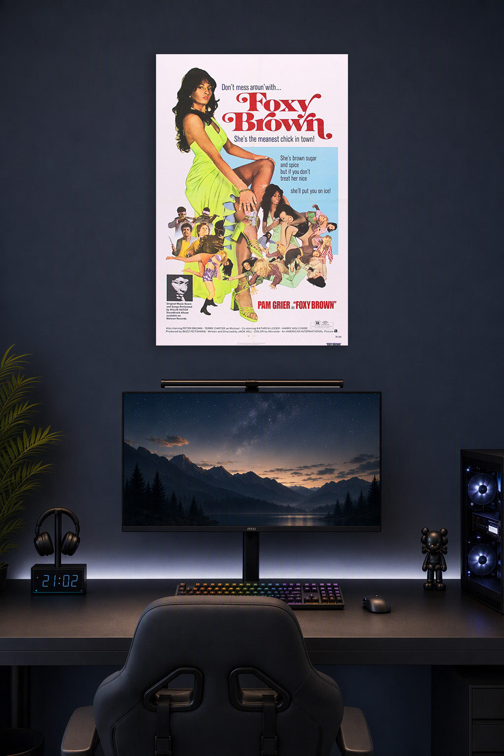 Foxy Brown in a gaming desk setup above a monitor.
