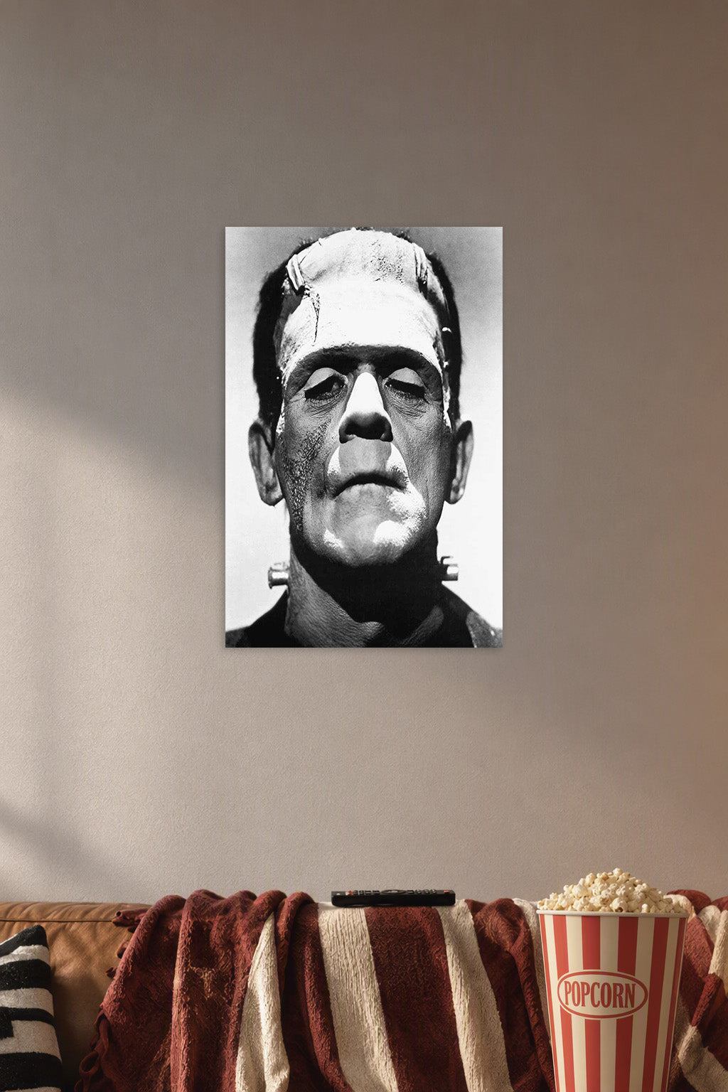 Frankenstein's Monster in a cozy movie room above a brown sofa with popcorn.