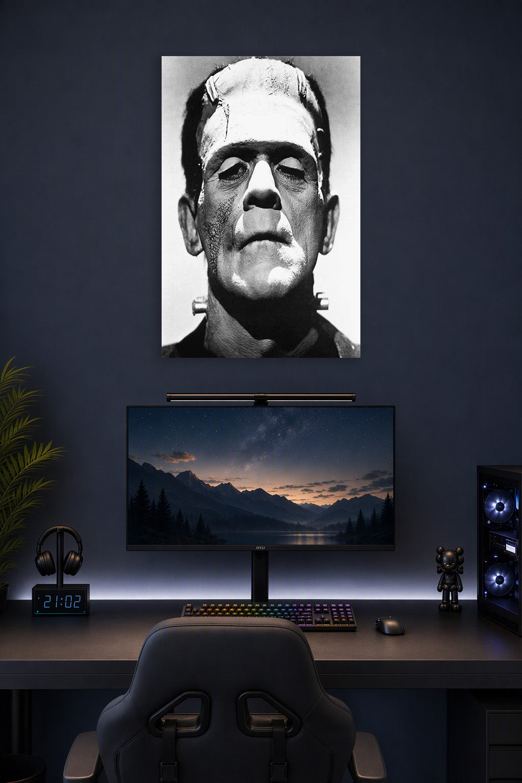 Frankenstein's Monster in a gaming desk setup above a monitor.