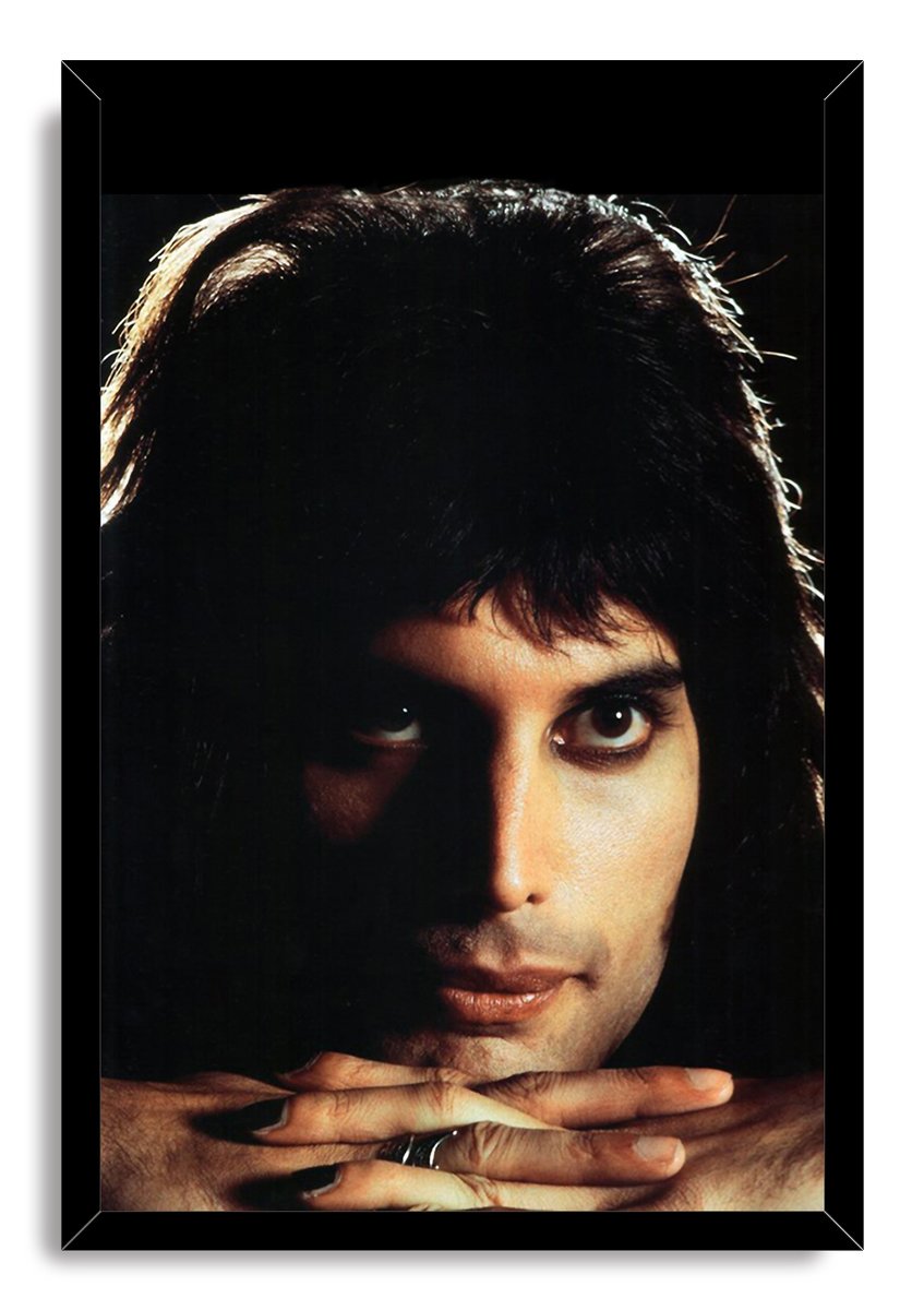 Freddie Mercury framed wall art print presents a dark close-up portrait with warm-lit face, folded hands, and black frame.