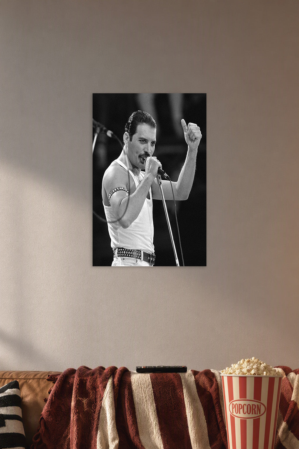 Freddie Mercury in a cozy movie room above a brown sofa with popcorn.