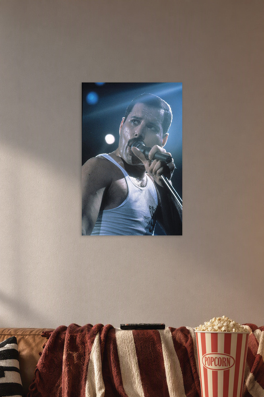 Freddie Mercury in a cozy movie room above a brown sofa with popcorn.