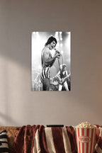 Freddie Mercury in a cozy movie room above a brown sofa with popcorn.