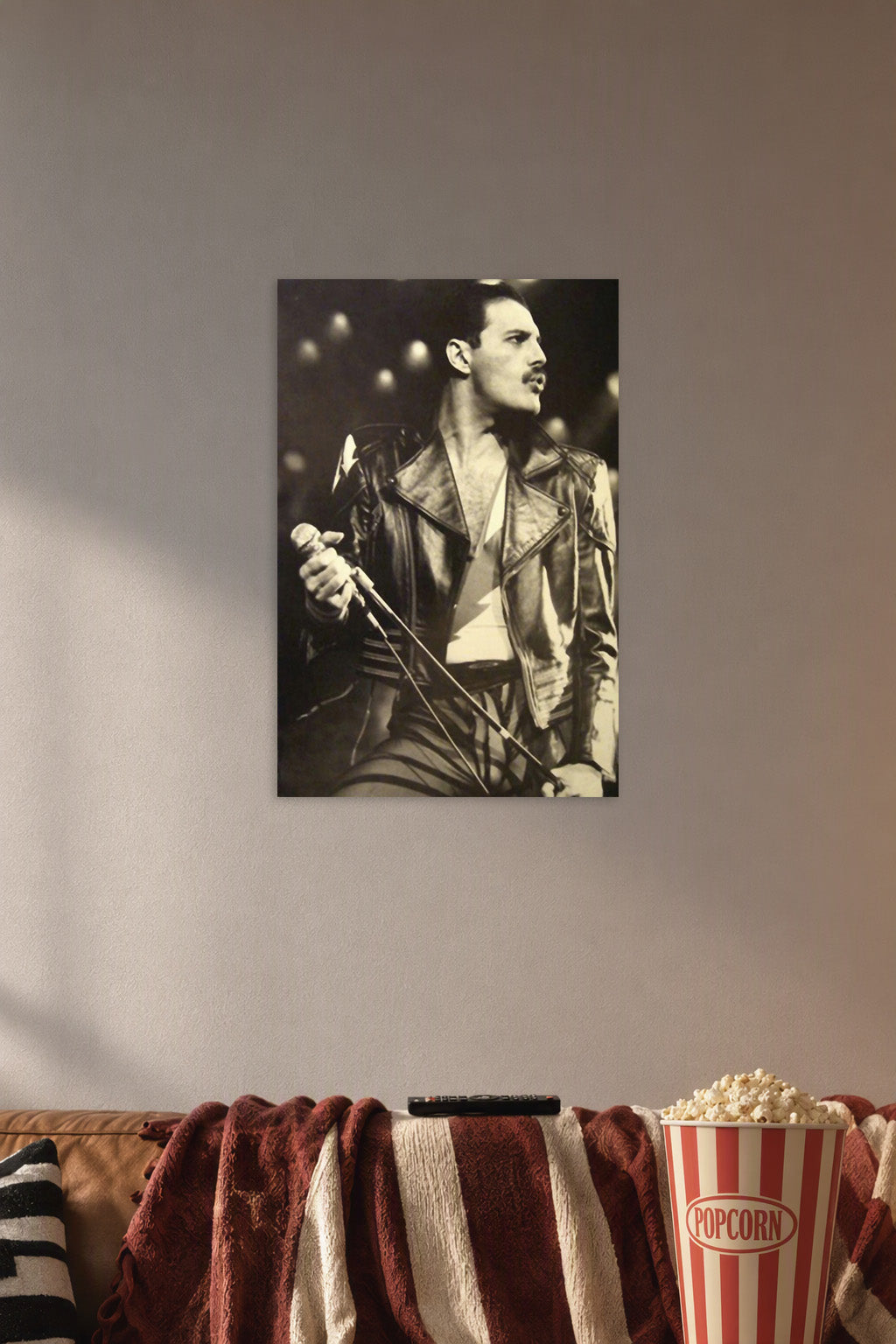 Freddie Mercury in a cozy movie room above a brown sofa with popcorn.