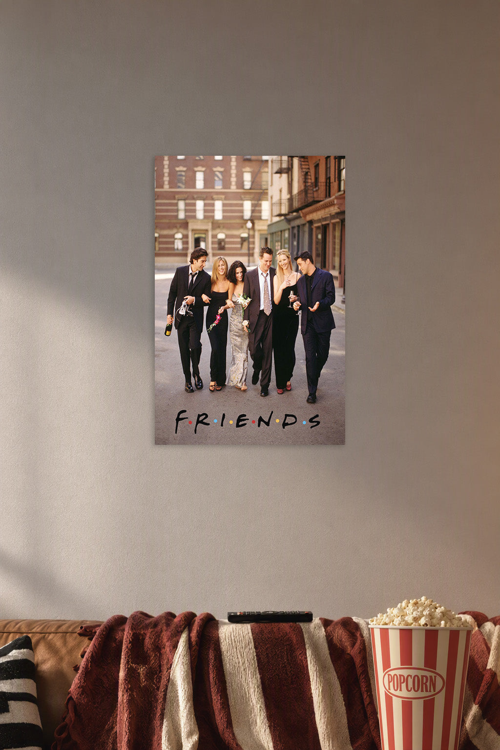 Friends TV Show Cast in a cozy movie room above a brown sofa with popcorn.