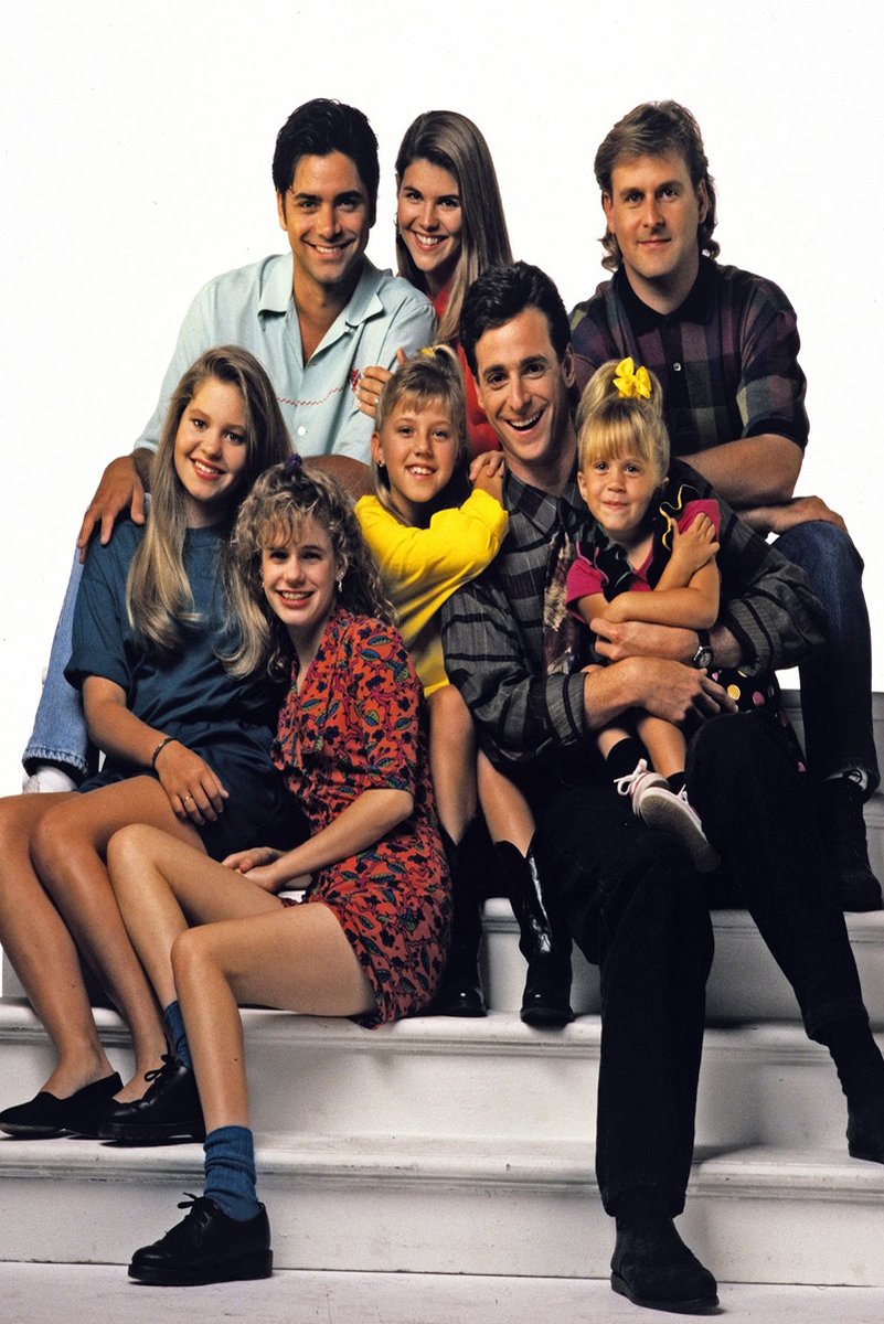 Full House cast poster features eight smiling adults and children posed together on white steps in colorful 1990s clothing.