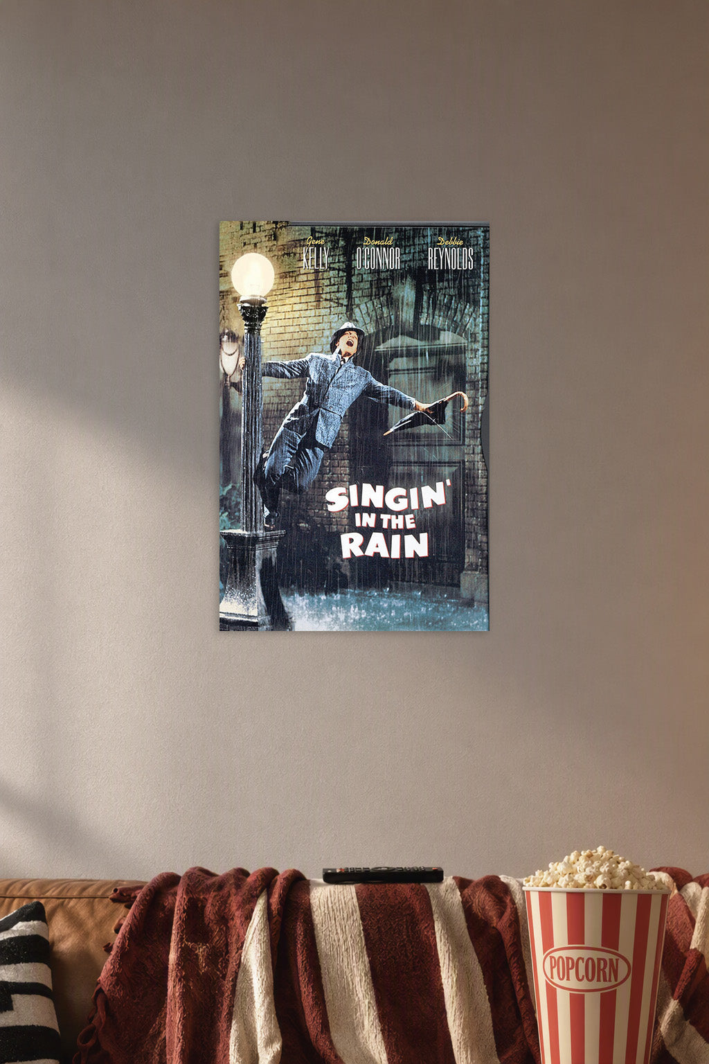 Gene Kelly Singin' in the Rain in a cozy movie room above a brown sofa with popcorn.