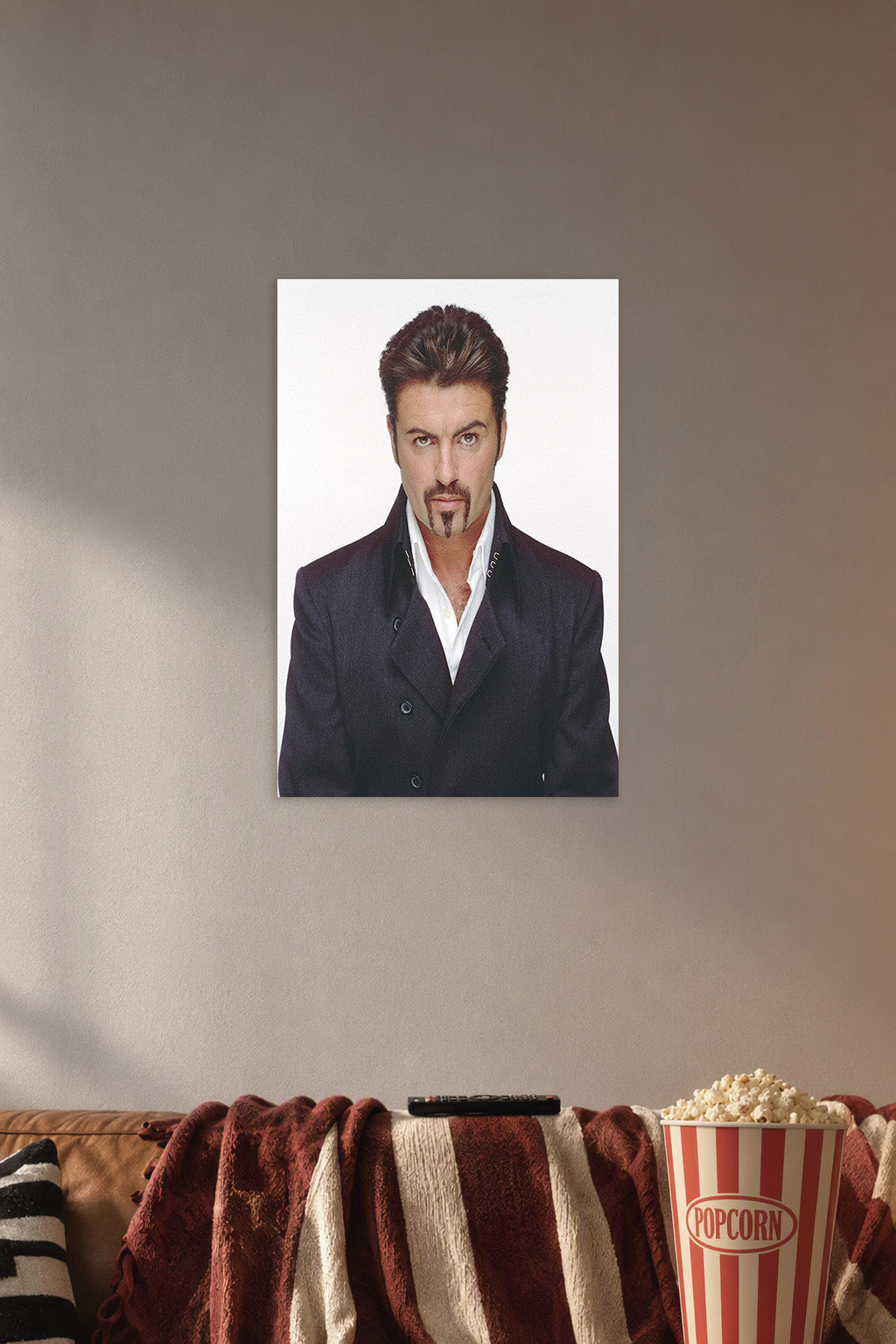 George Michael in a cozy movie room above a brown sofa with popcorn.