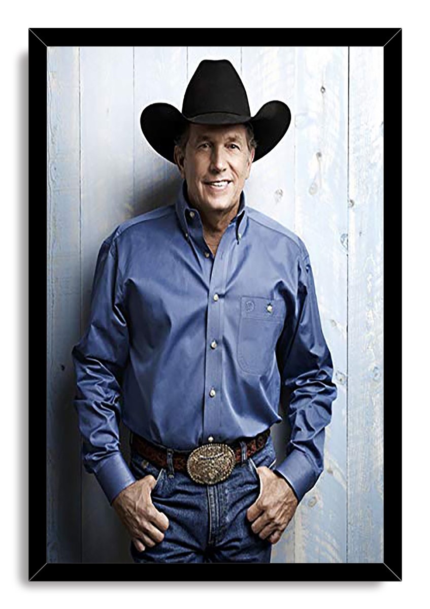 George Strait framed wall art print in a black frame, with the singer in western attire posed before a light wooden wall.