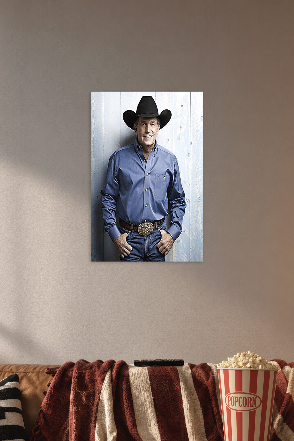 George Strait in a cozy movie room above a brown sofa with popcorn.